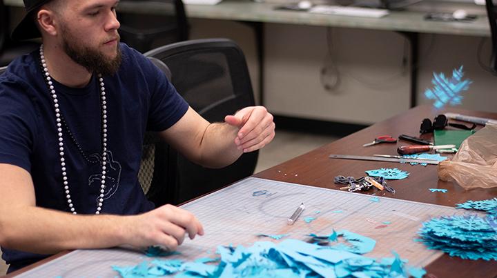 Austin Draving cutting out snowflakes